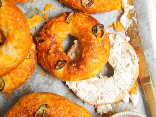 Cottage cheese bagels on a baking tray with Boursin cheese on the side.