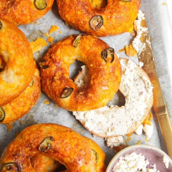 Cottage cheese bagels on a baking tray with Boursin cheese on the side.