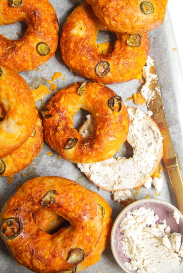 Cottage cheese bagels on a baking tray with Boursin cheese on the side.