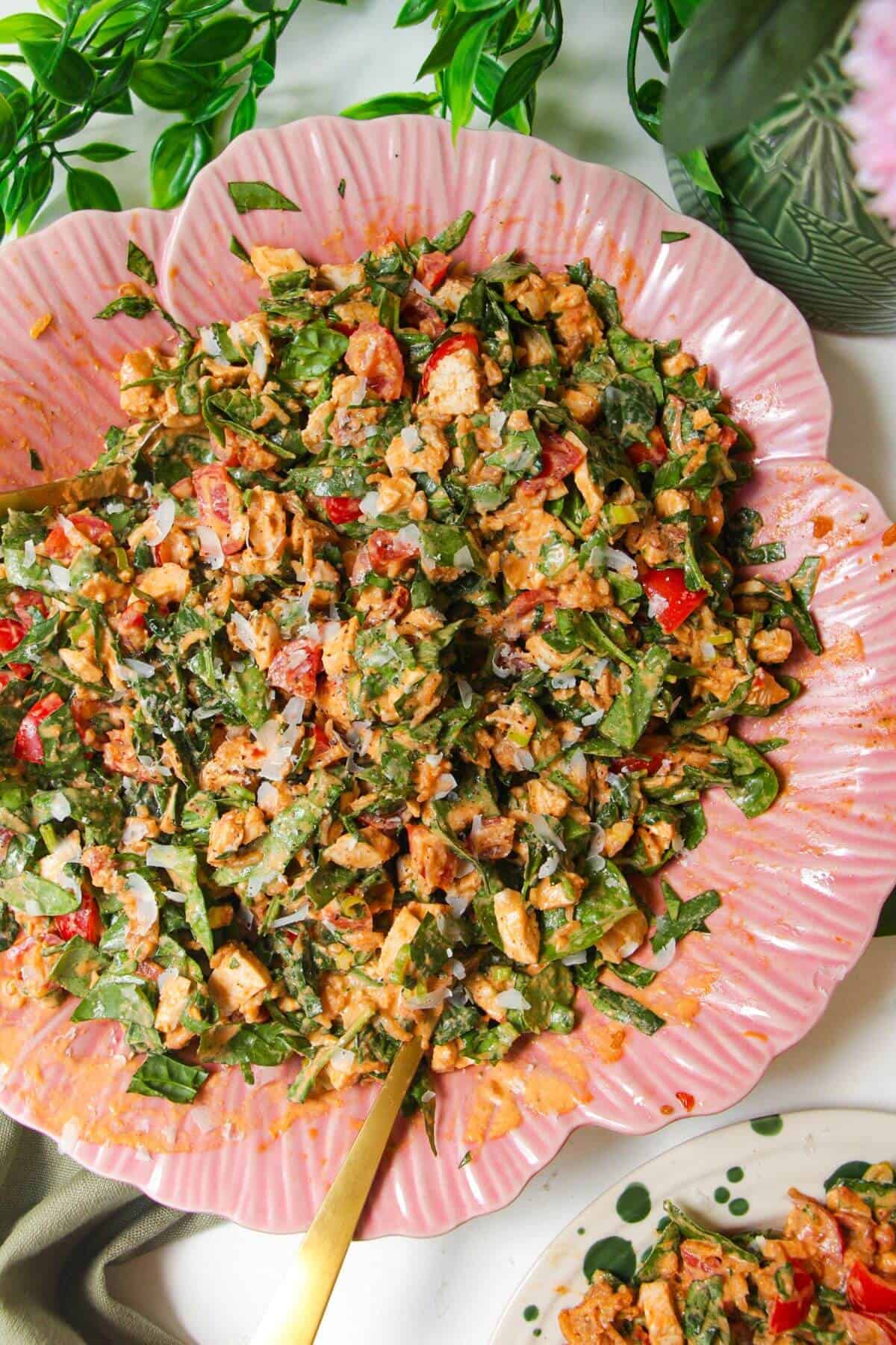'Marry Me' chicken crispy rice salad in a pink flower bowl with a small plate on the side.