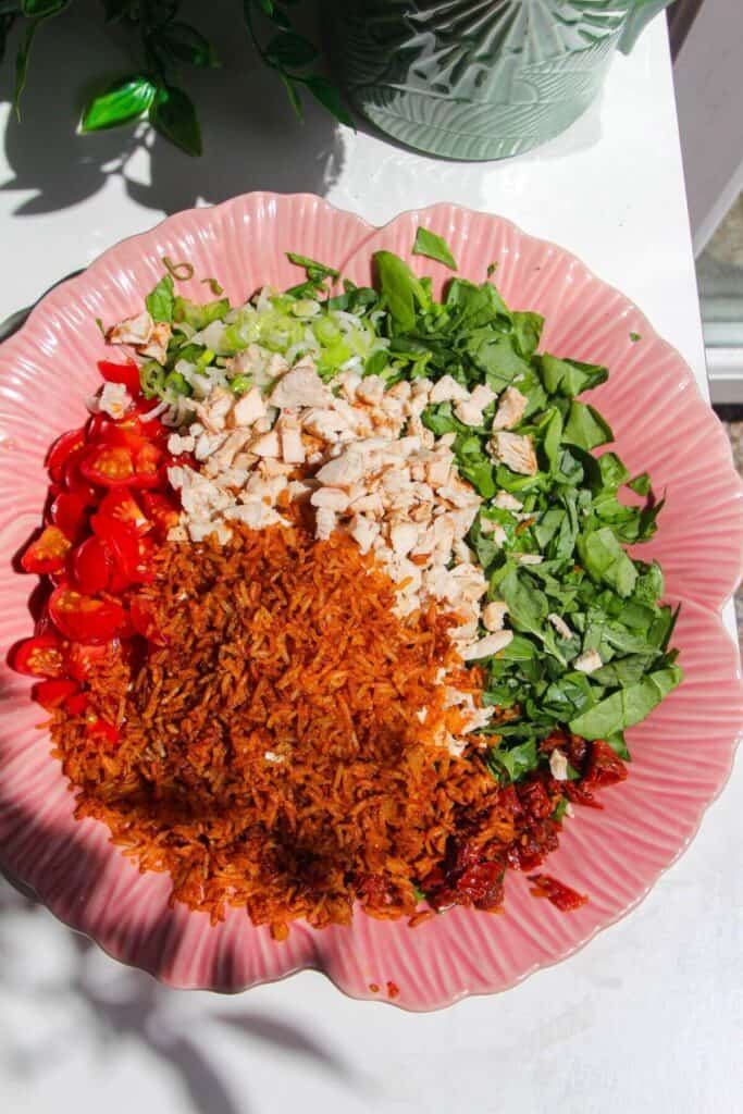 Ingredients for 'Marry Me' chicken crispy rice salad in a pink bowl.
