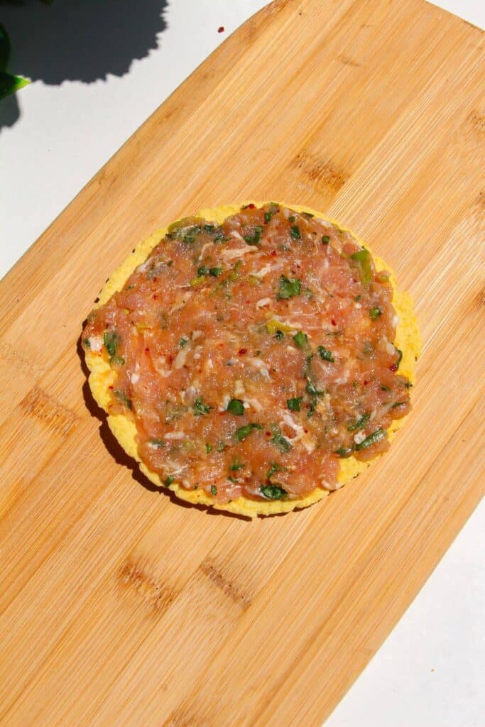 Chicken mixture spread onto mini tortilla.
