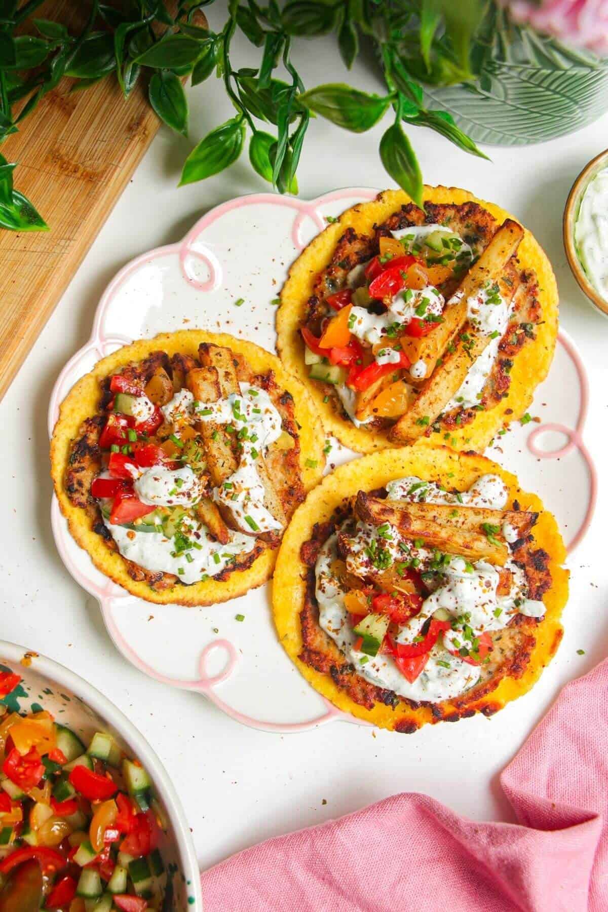 Three smash chicken gyros tacos on a small serving plate.
