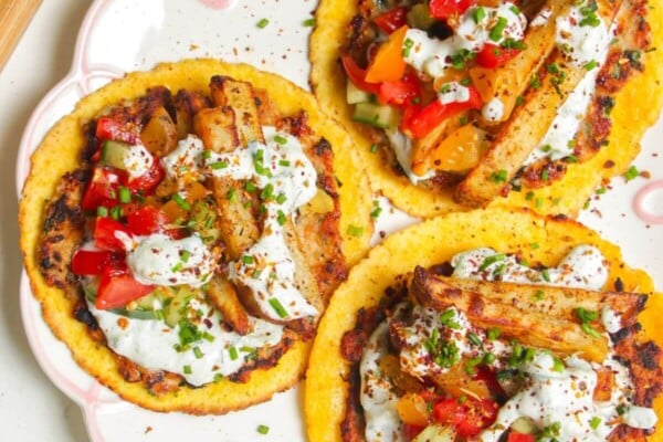 Three chicken gyros smash tacos laid out on a plate.