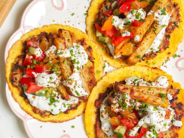 Three chicken gyros smash tacos laid out on a plate.