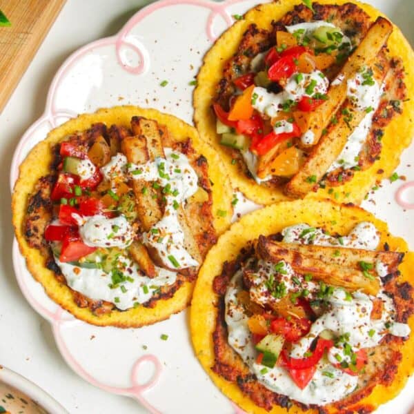 Three chicken gyros smash tacos laid out on a plate.