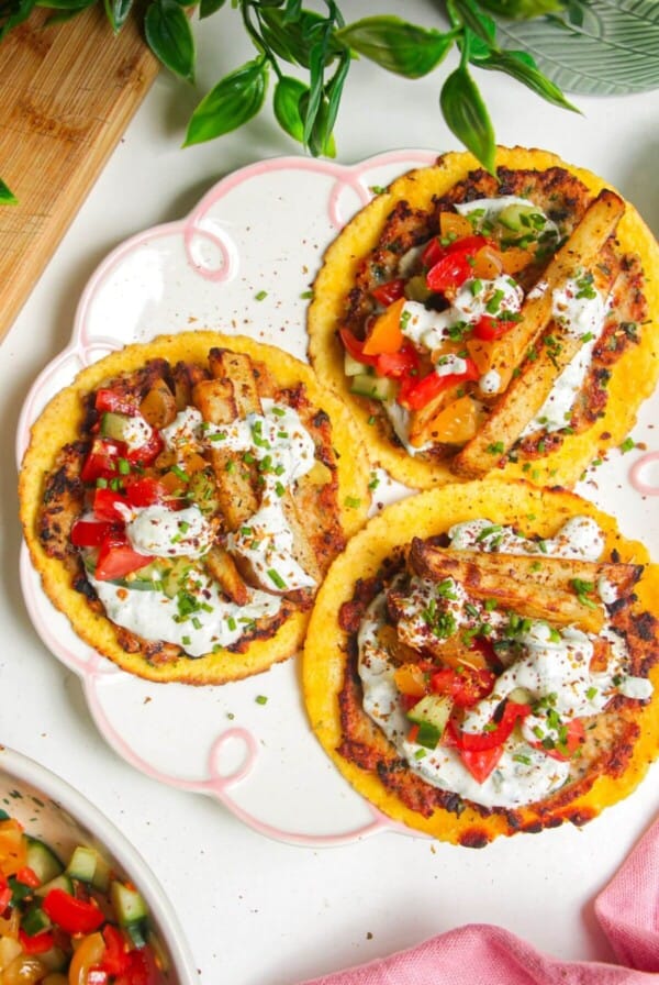 Three chicken gyros smash tacos laid out on a plate.