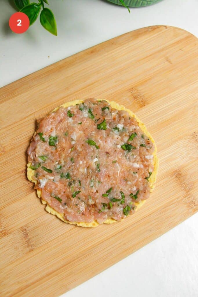 Ground chicken gyros mixture pressed onto mini tortilla.