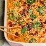Baked satay ramen in an oven dish, with chopsticks on the side.