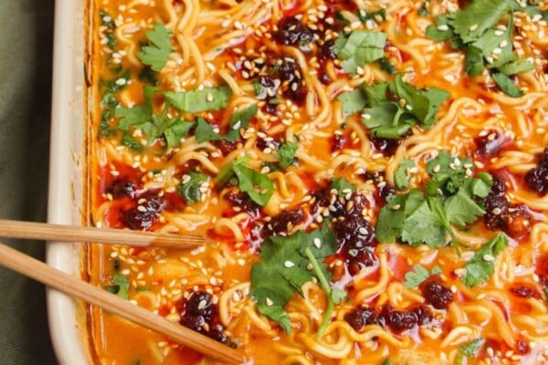 Baked satay ramen in an oven dish, with chopsticks on the side.