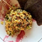 Chicken salad in a bowl with nori sheets on the side.
