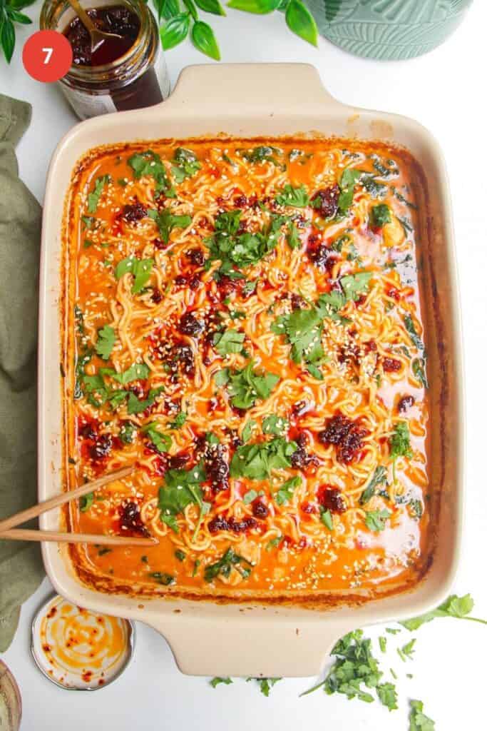 Baked satay ramen in an oven dish, topped with chili oil and cilantro.