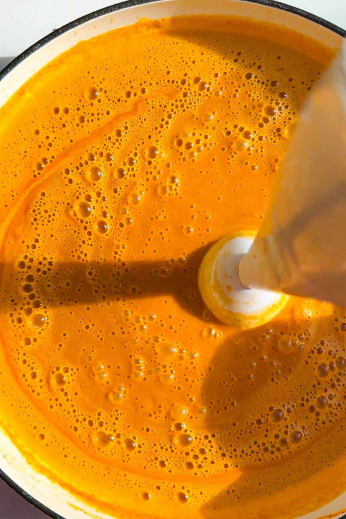 Stick blender blitzing butternut squash coconut broth.