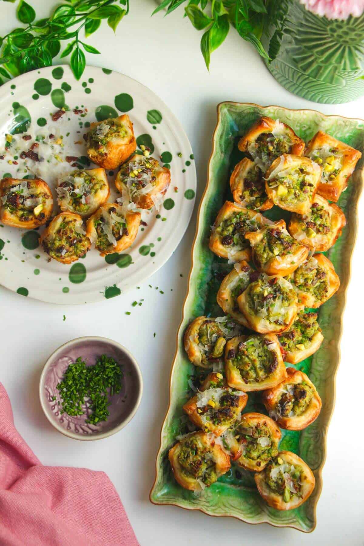 Pesto ricotta puff pastry cups laid out on serving plates.