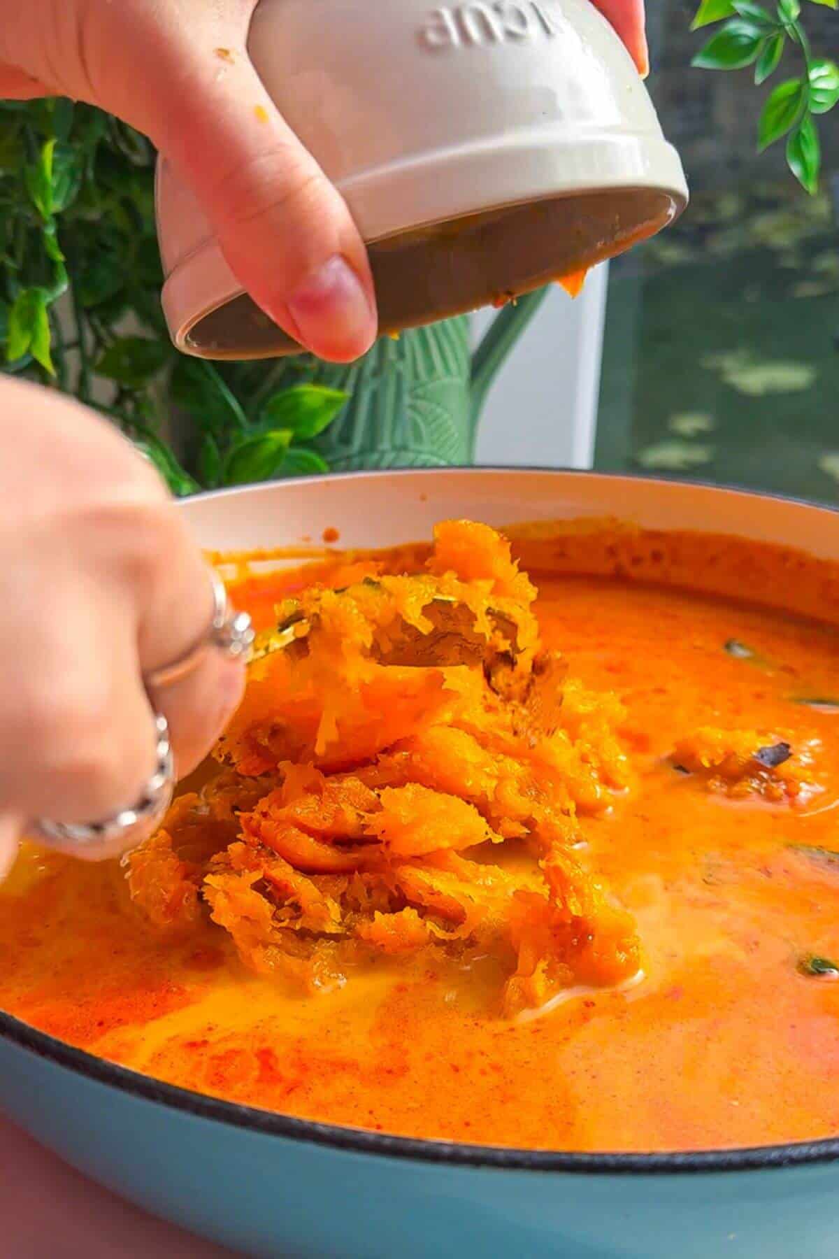 Adding butternut squash flesh to coconut gochujang broth.