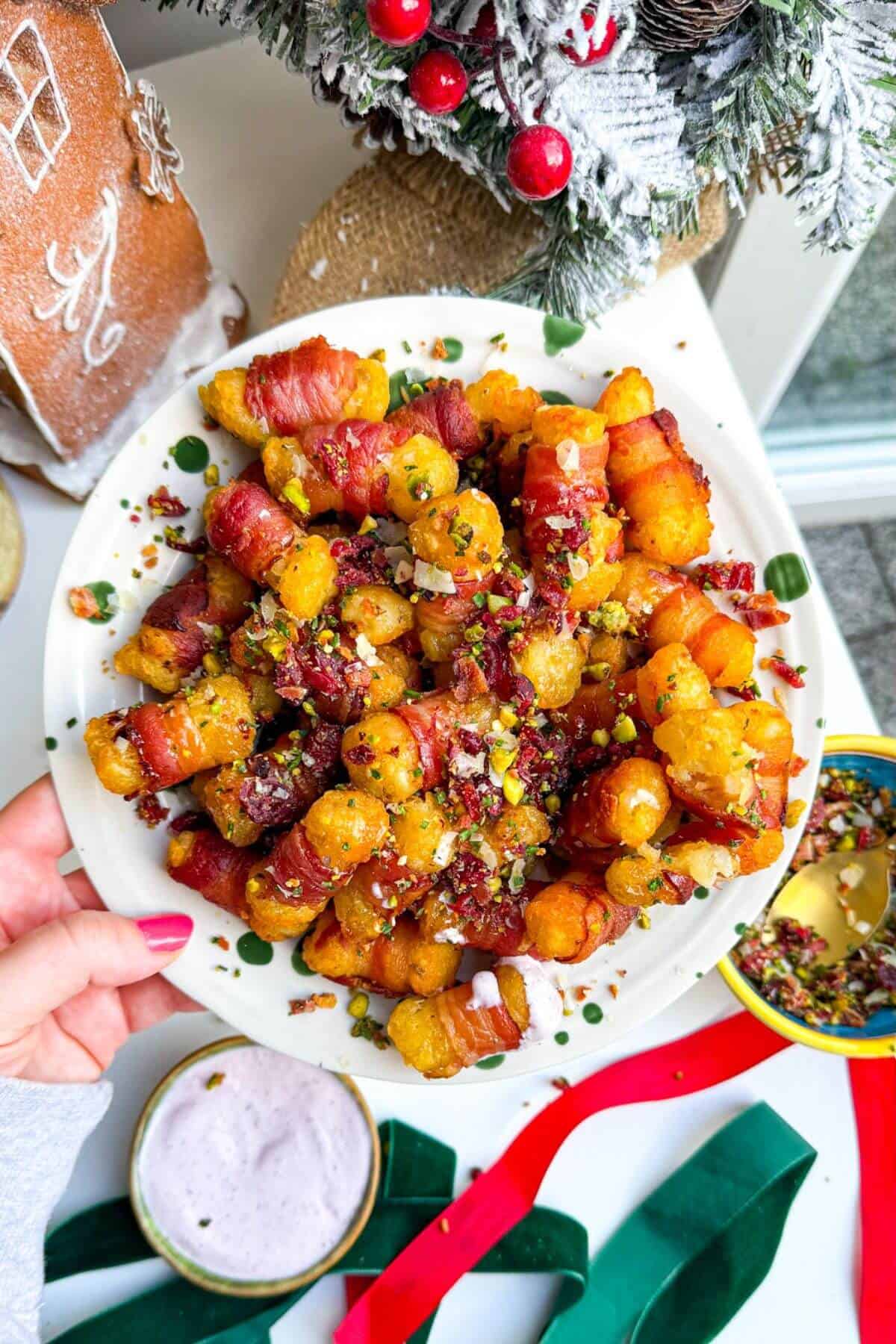 Bacon wrapped tater tots drizzled with honey and nuts on a plate.