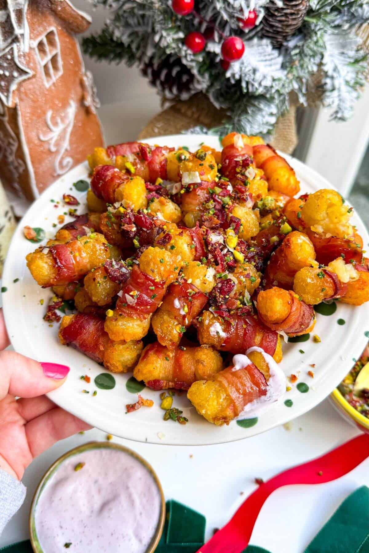 Bacon wrapped tater tots drizzled with honey and nuts on a plate.