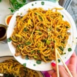 Dumpling noodles on a serving plate with chopsticks.