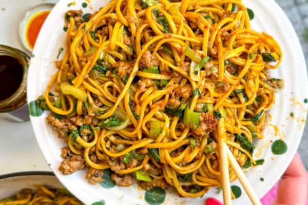 Dumpling noodles on a serving plate with chopsticks.
