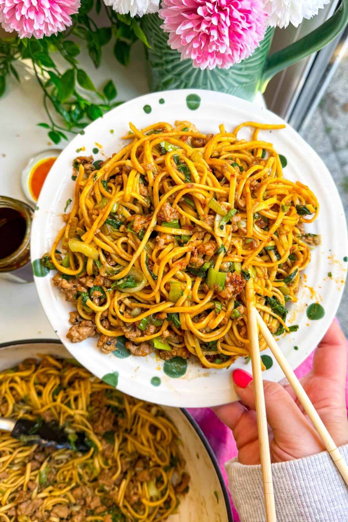 Dumpling noodles on a serving plate with chopsticks.
