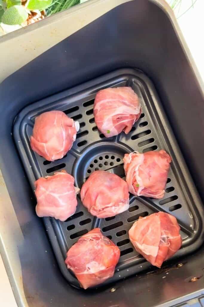 Prosciutto brie bombs in an air fryer basket.