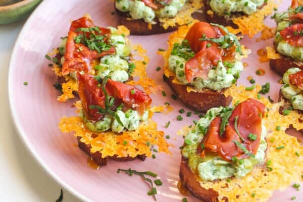 Herby ricotta cheesy crostini on a serving platter.