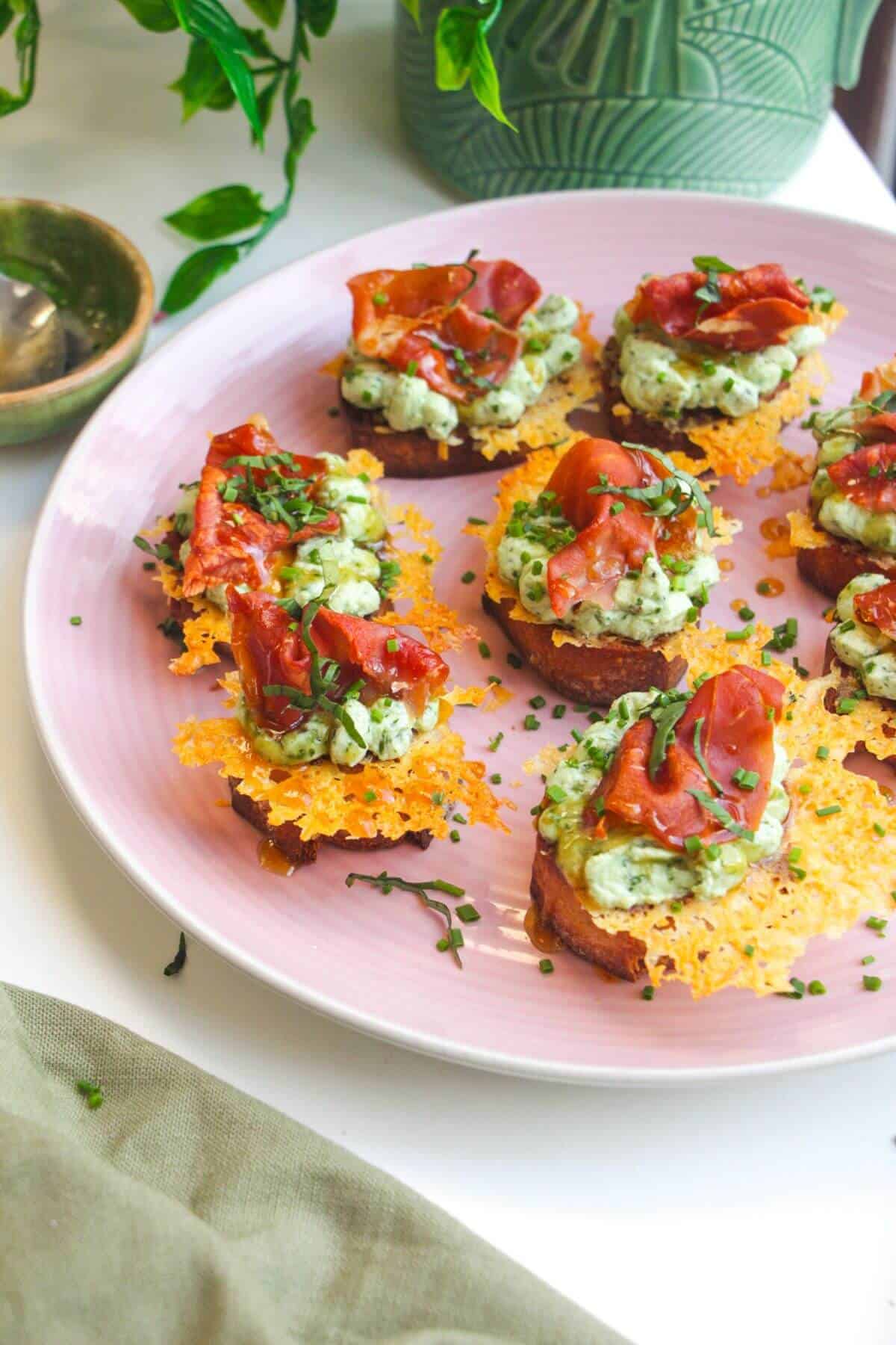 Herby ricotta cheesy crostini on a serving platter.
