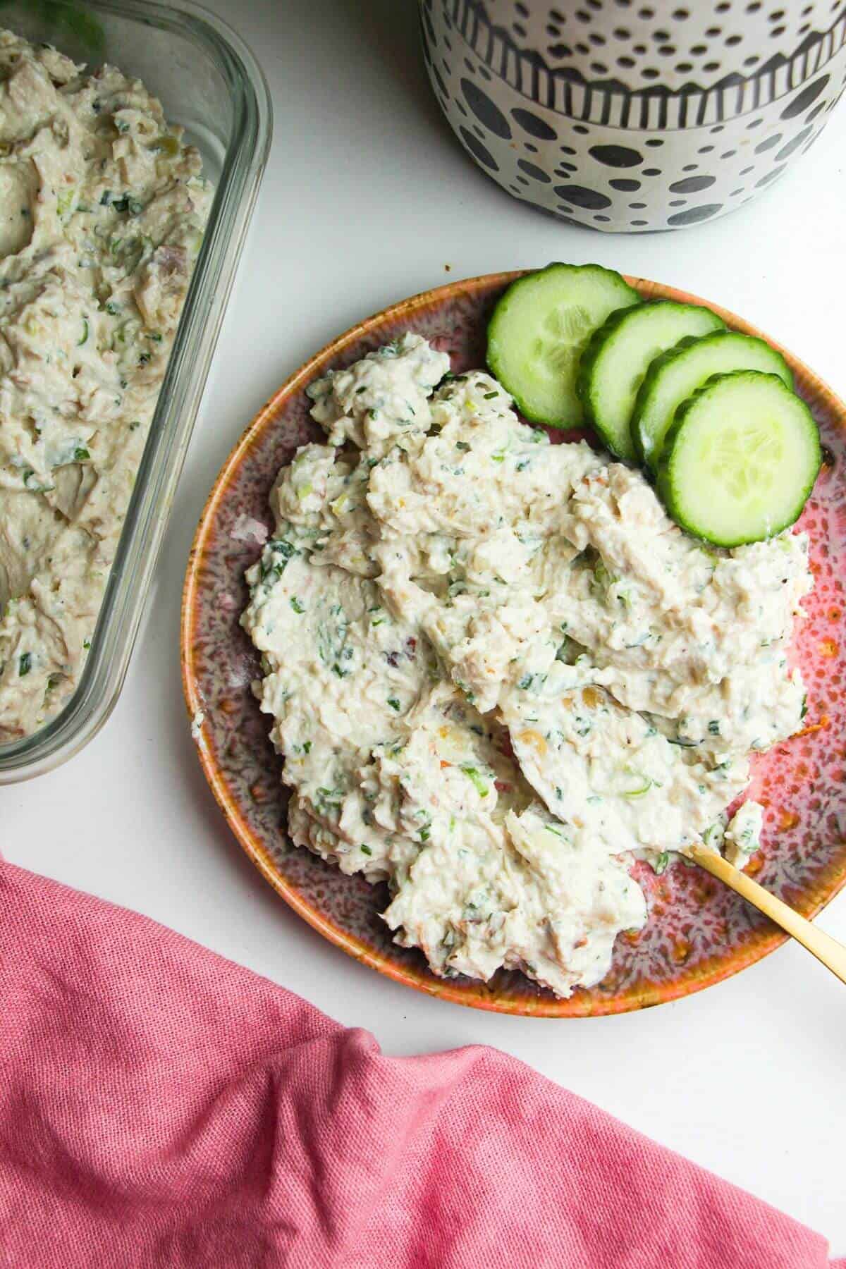 Caesar inspired chicken salad on serving plate with cucumber on the side.