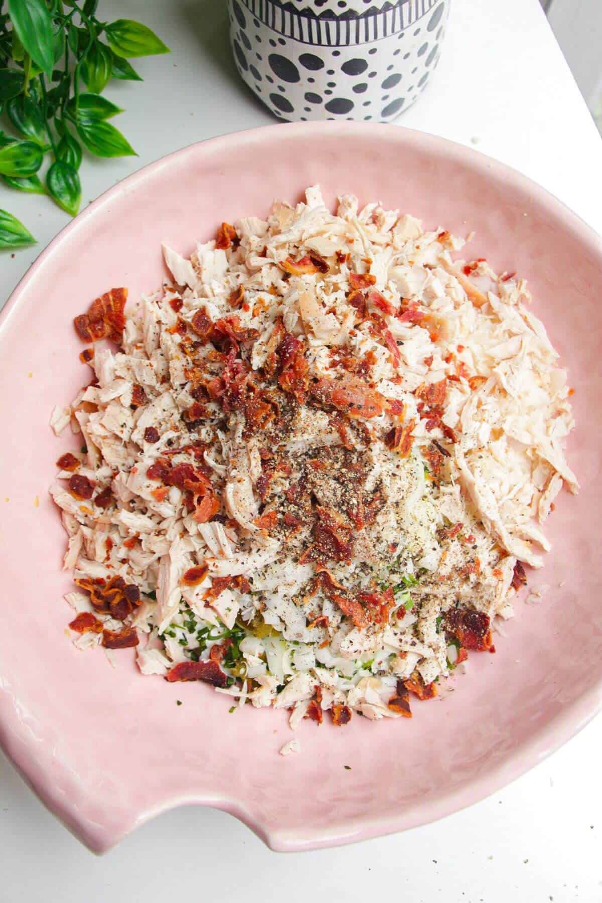 Ingredients for Caesar inspired chicken salad in a large mixing bowl.