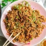 Holding a plate of dumpling inspired fried rice.