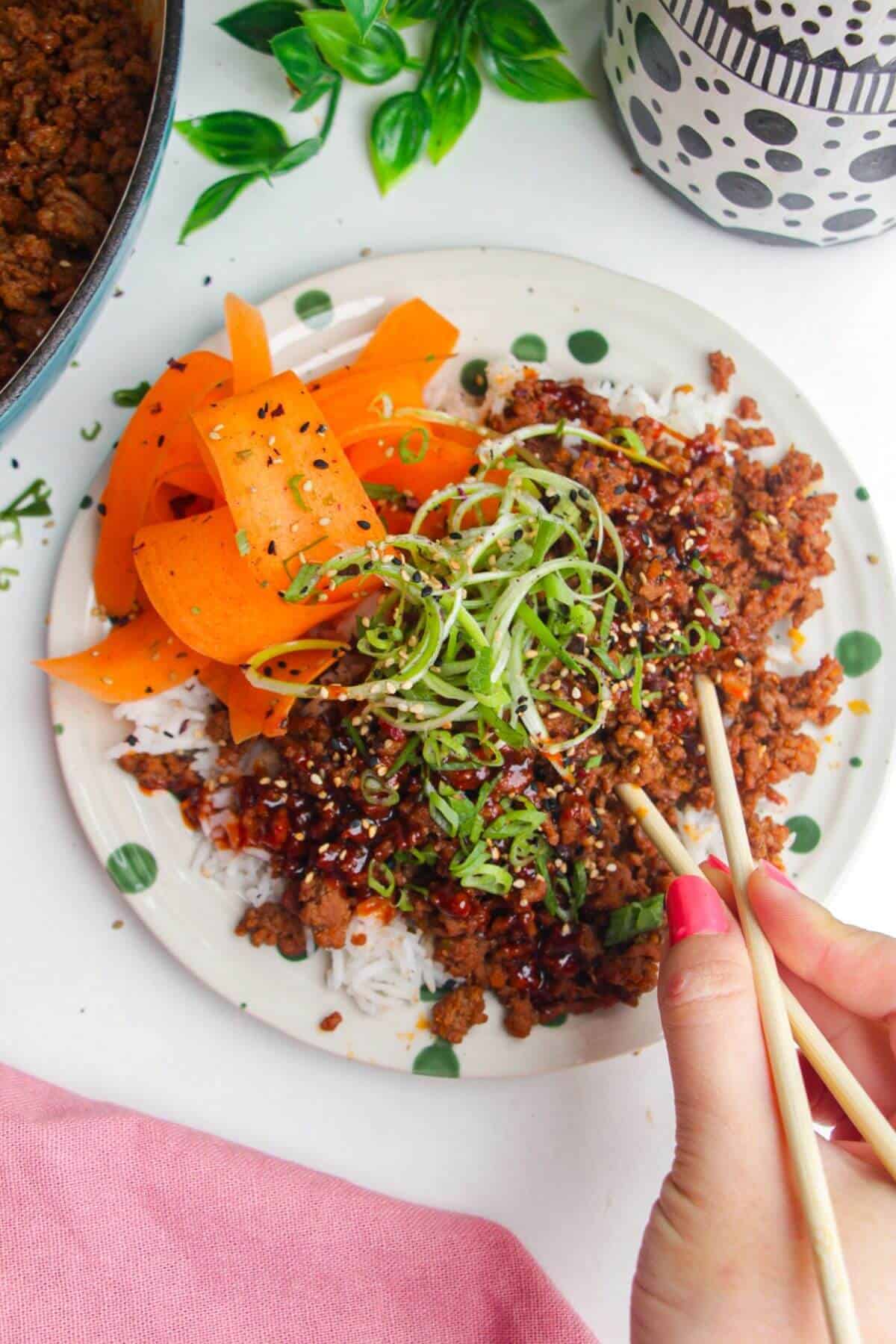 Using chopsticks with a sticky gochujang beef bowl.