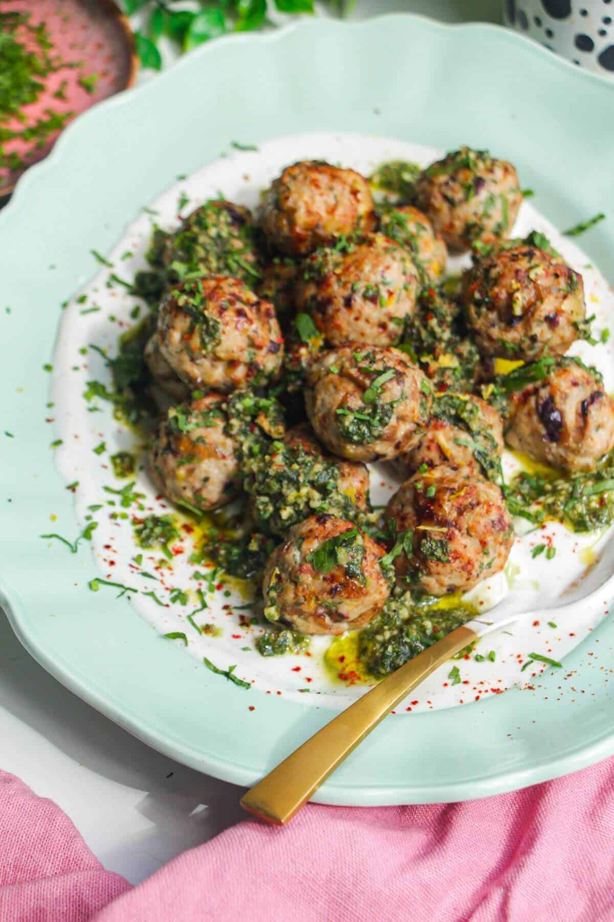 Lemony chicken meatballs on whipped feta, with a spoon.