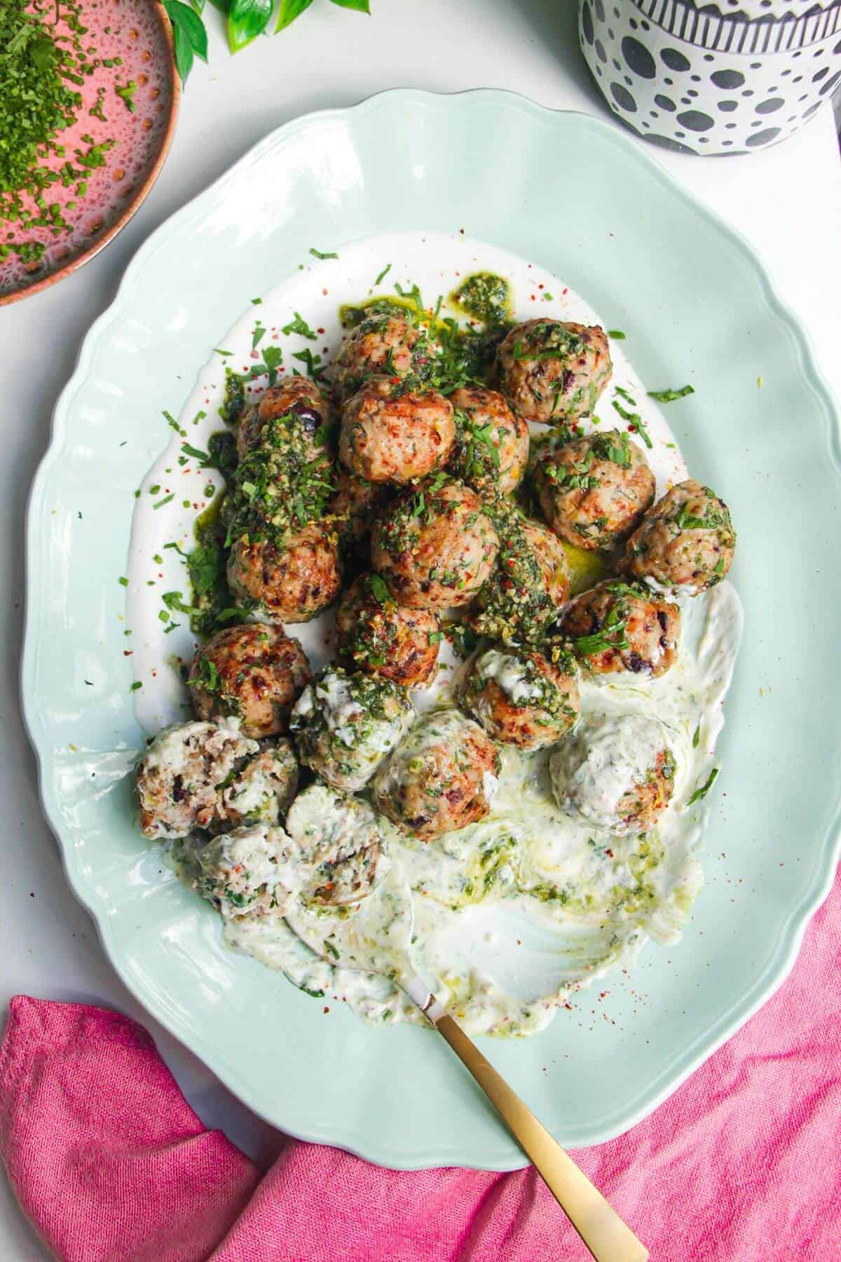 Lemony chicken meatballs on whipped feta, with a spoon.