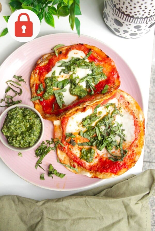 Chicken parm tacos on a platter with basil pesto.