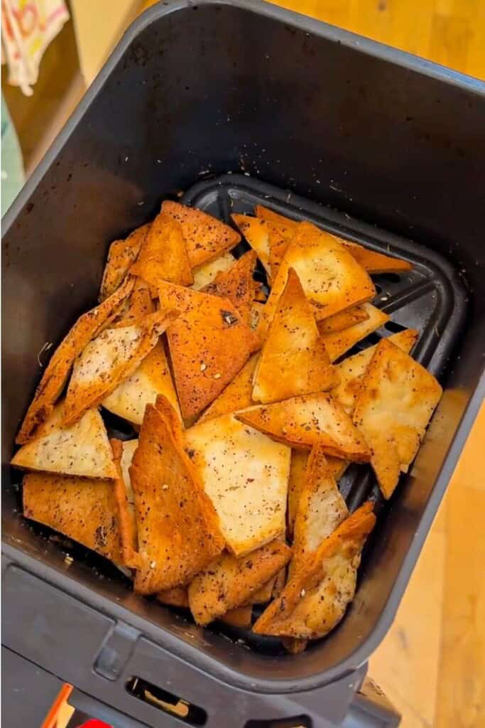 Pita chips in air fryer basket.