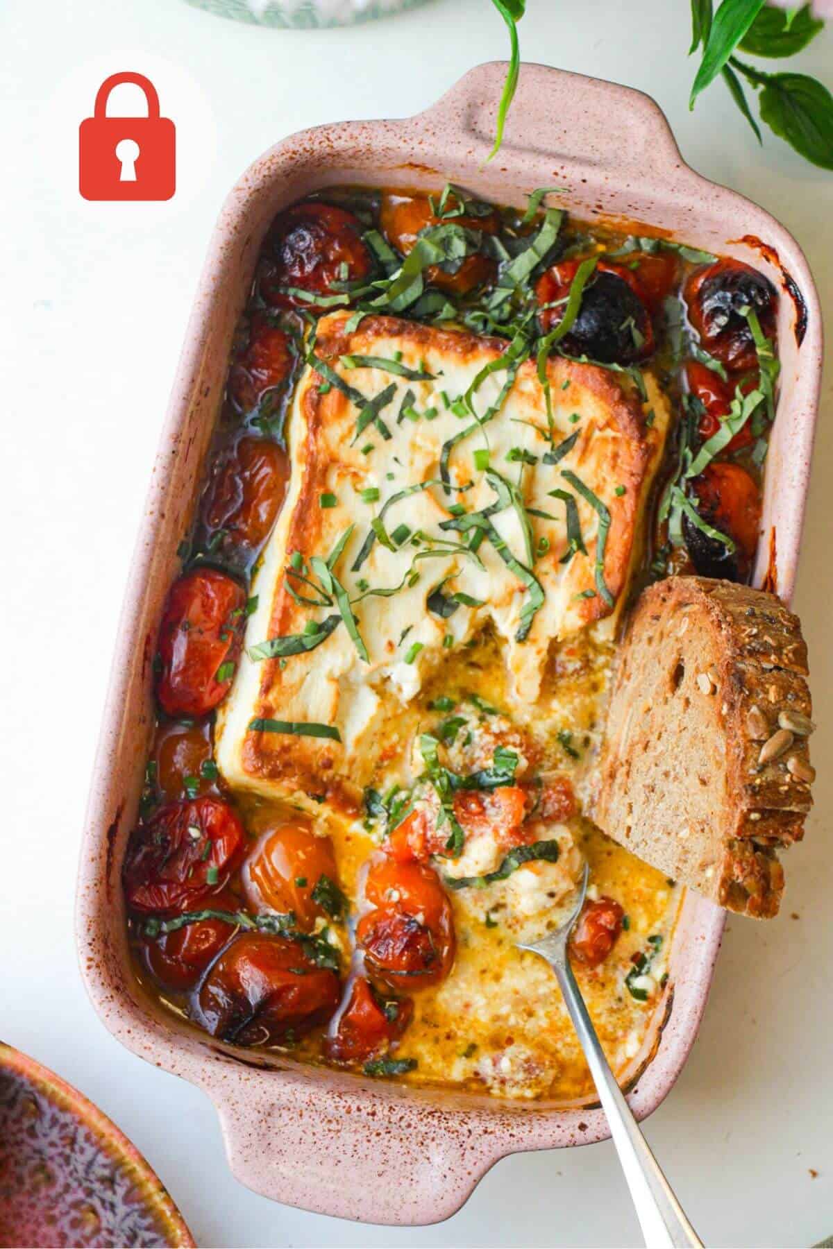 Baked feta tomato dip with bread in the dish.