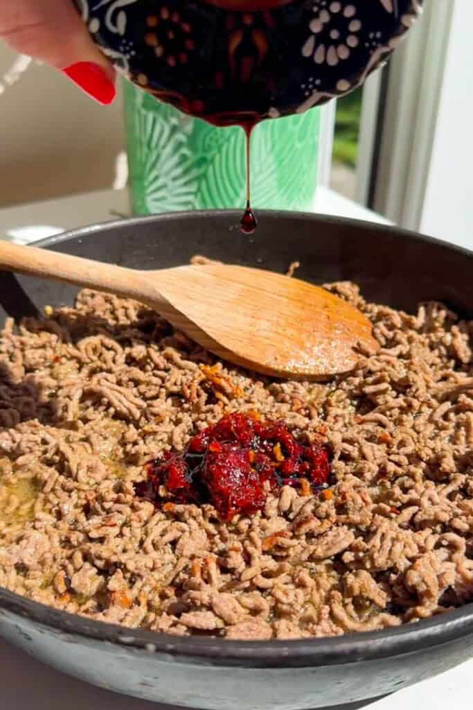 Harissa paste and seasoning added to ground beef.