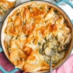 Spanokopita chicken pot pie, with a serving spoon in the pan.