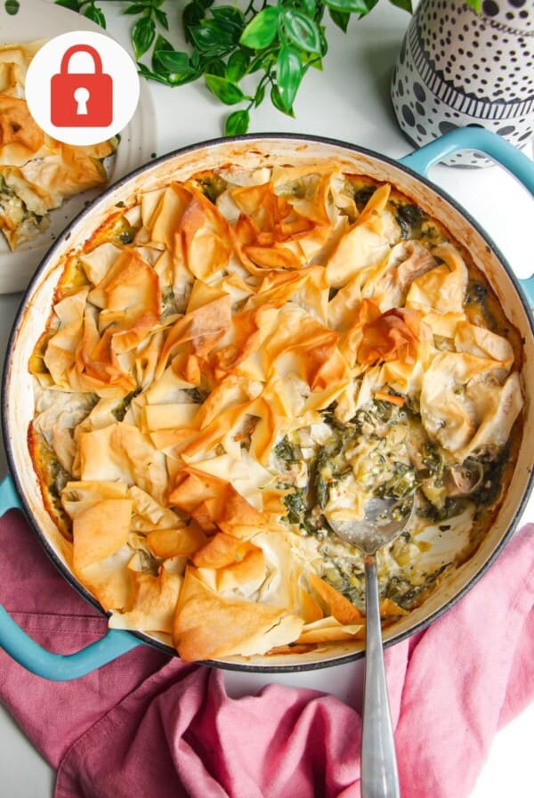 Spanokopita chicken pot pie, with a serving spoon in the pan.