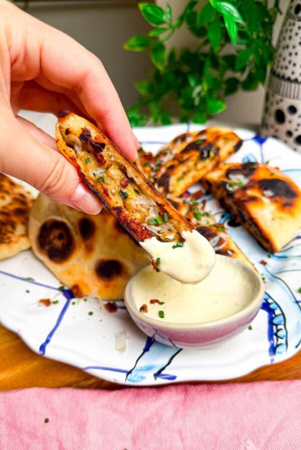 Dipping Caesar stuffed flatbread in Caesar dipping sauce.