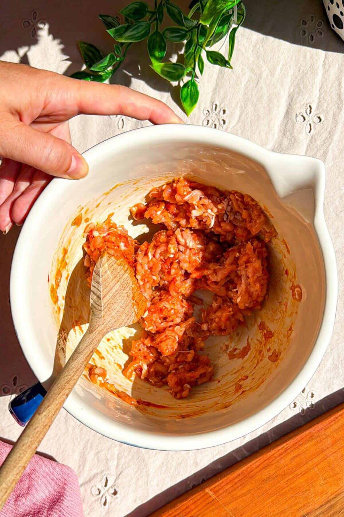 Mixing Korean chicken topping for smash tacos in bowl.