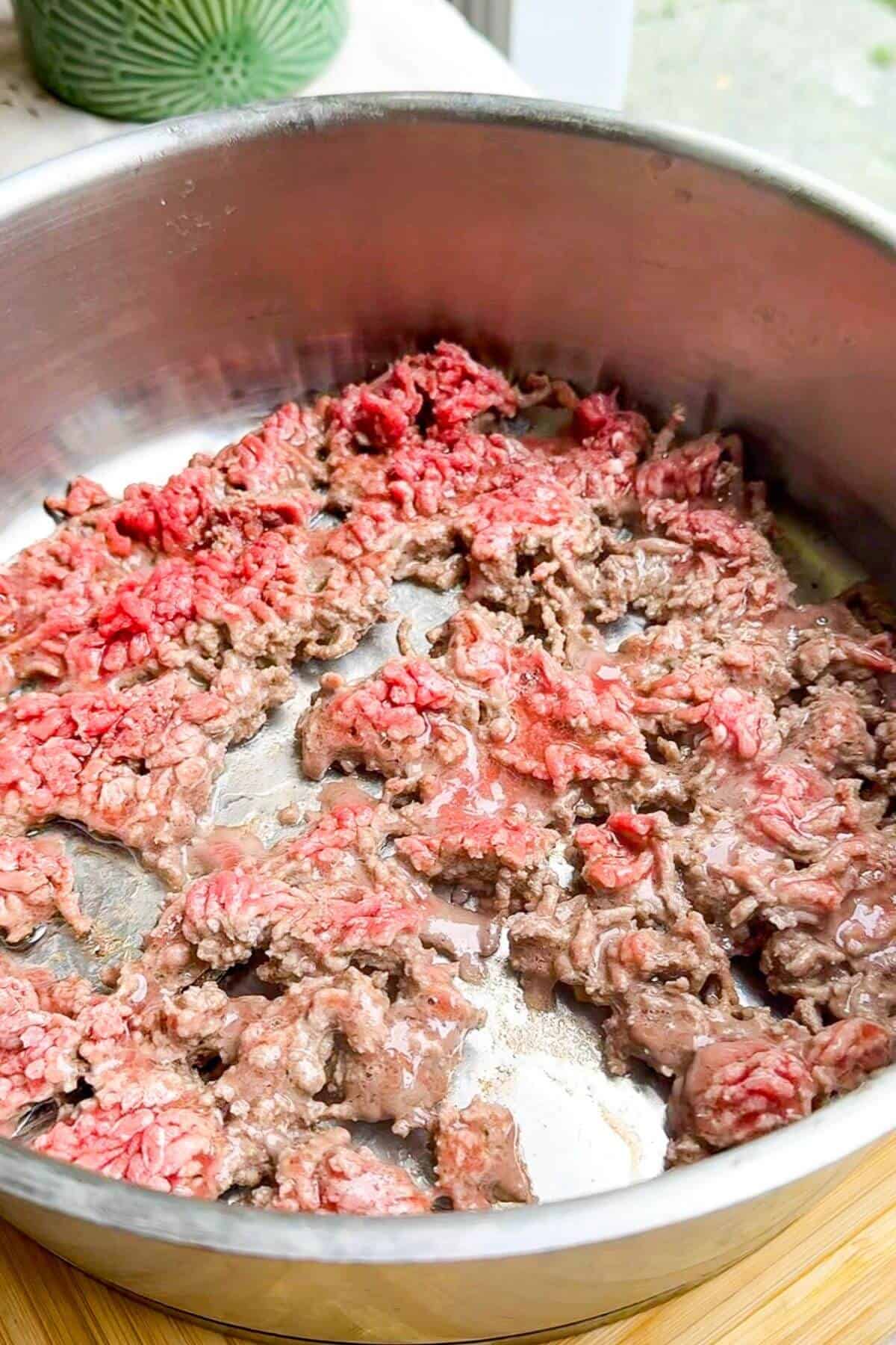 Ground beef cooking in a pan.