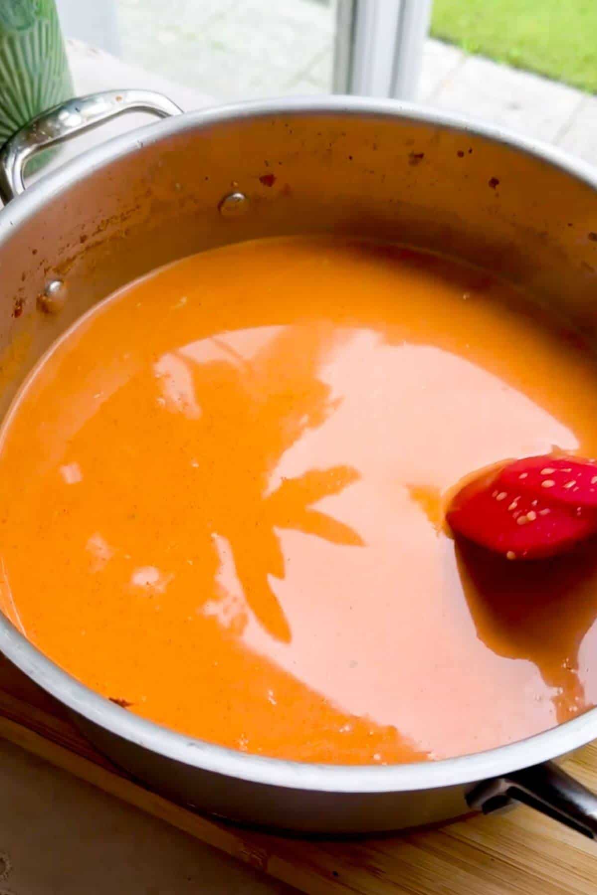 Coconut gochujang broth in pan.
