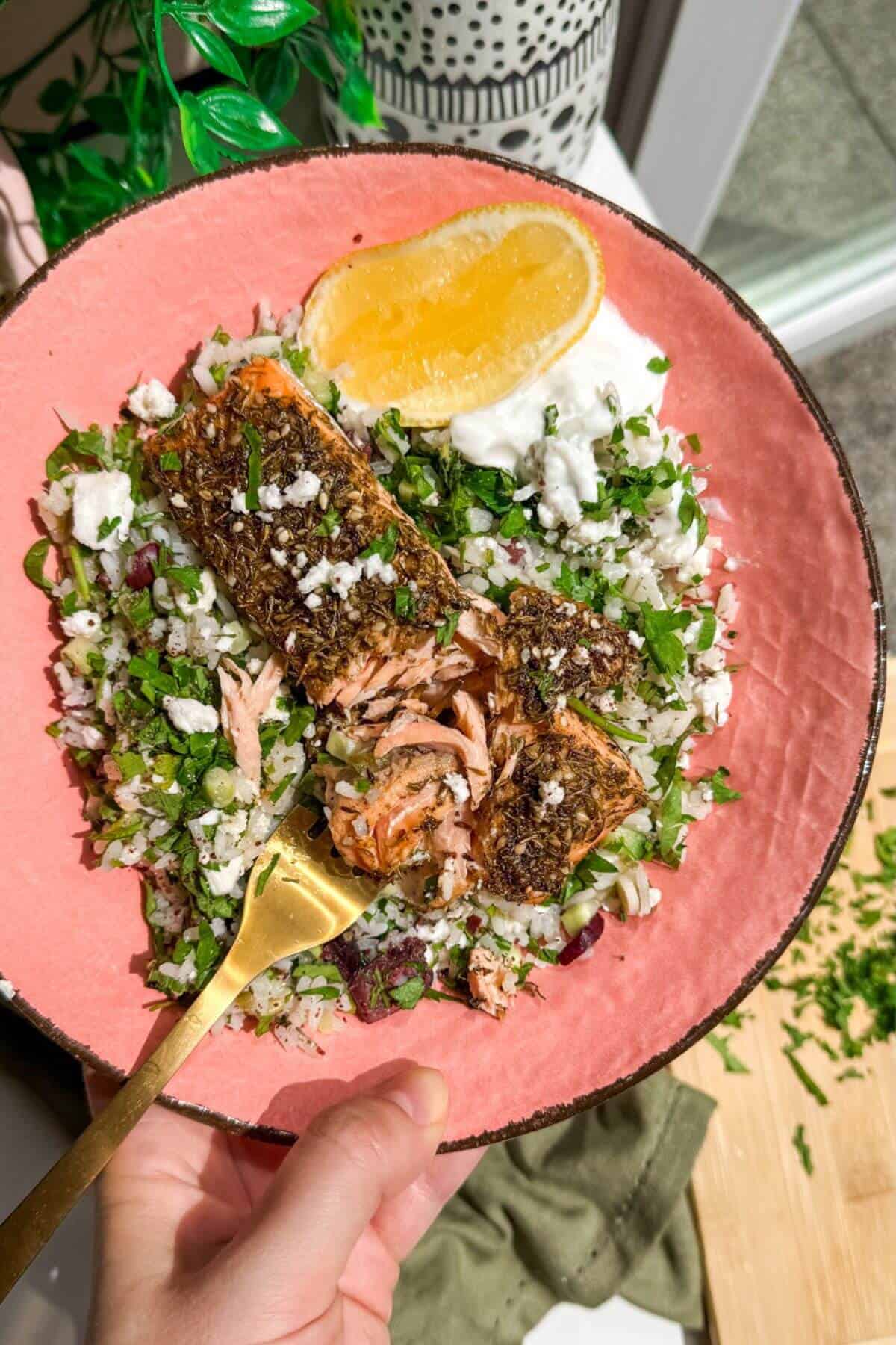 Za'atar crusted salmon, on herby rice salad in a bowl.
