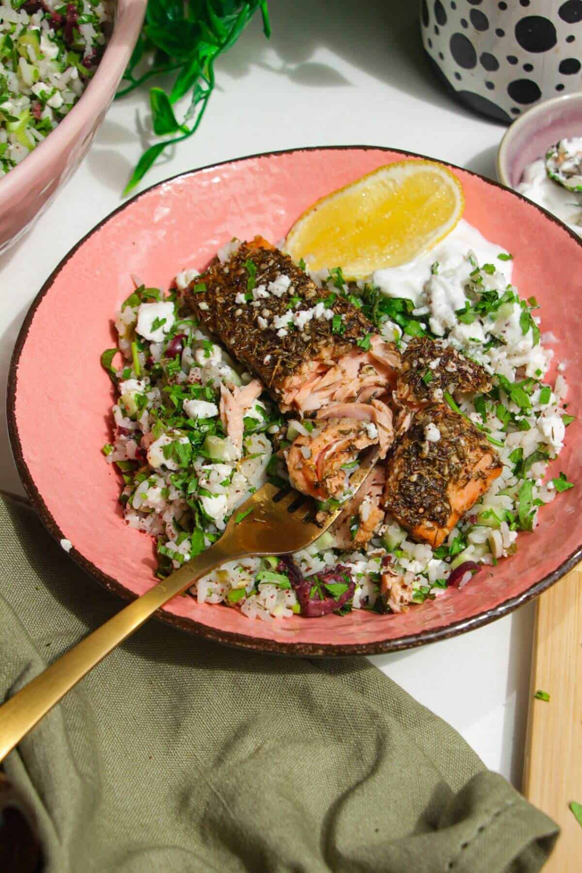 Za'atar crusted salmon, on herby rice salad in a bowl.